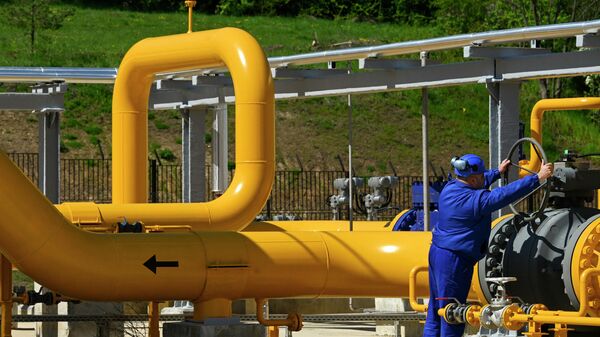 Сотрудник поворачивает вентиль на газокомпрессорной станции  - Sputnik Азербайджан