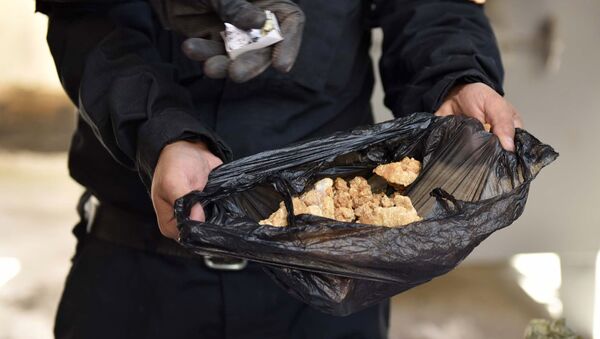 Сотрудник правоохранительных органов демонстрирует пакет с наркотиками в антинаркотическом ведомстве, фото из архива - Sputnik Азербайджан